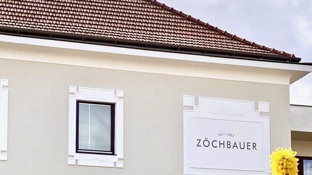 Un edificio con un letrero que dice "ZÖCHBAUER" y "Gästehaus".