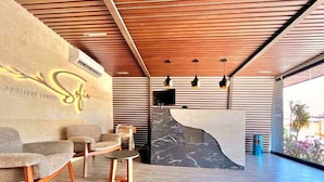 Una moderna zona de recepción con pared de piedra, techo de madera y asientos.