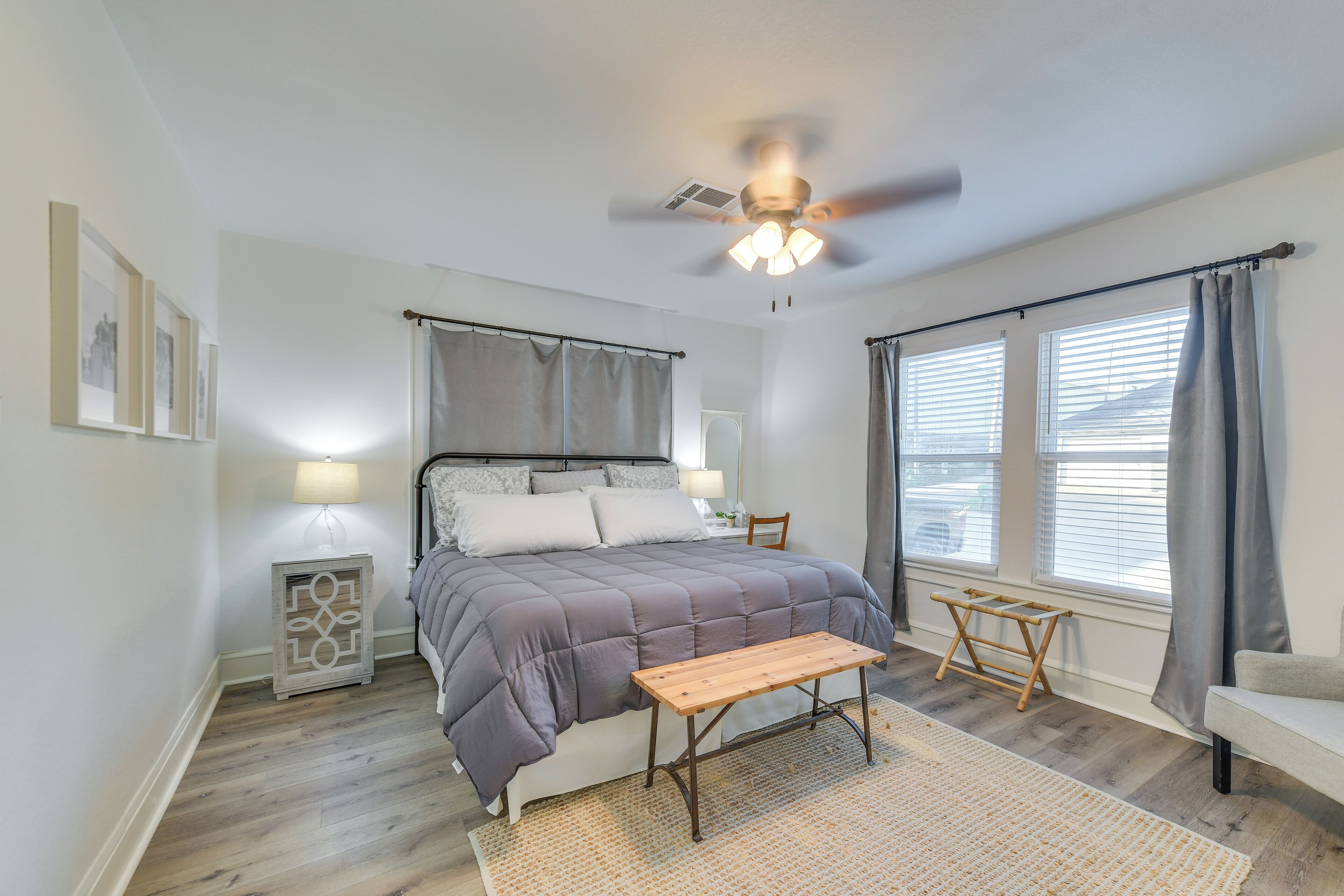 Ein Schlafzimmer mit Bett, Nachttisch, Lampe und Deckenventilator.