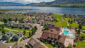 Un quartier résidentiel avec des maisons, une piscine et un lac en arrière-plan.