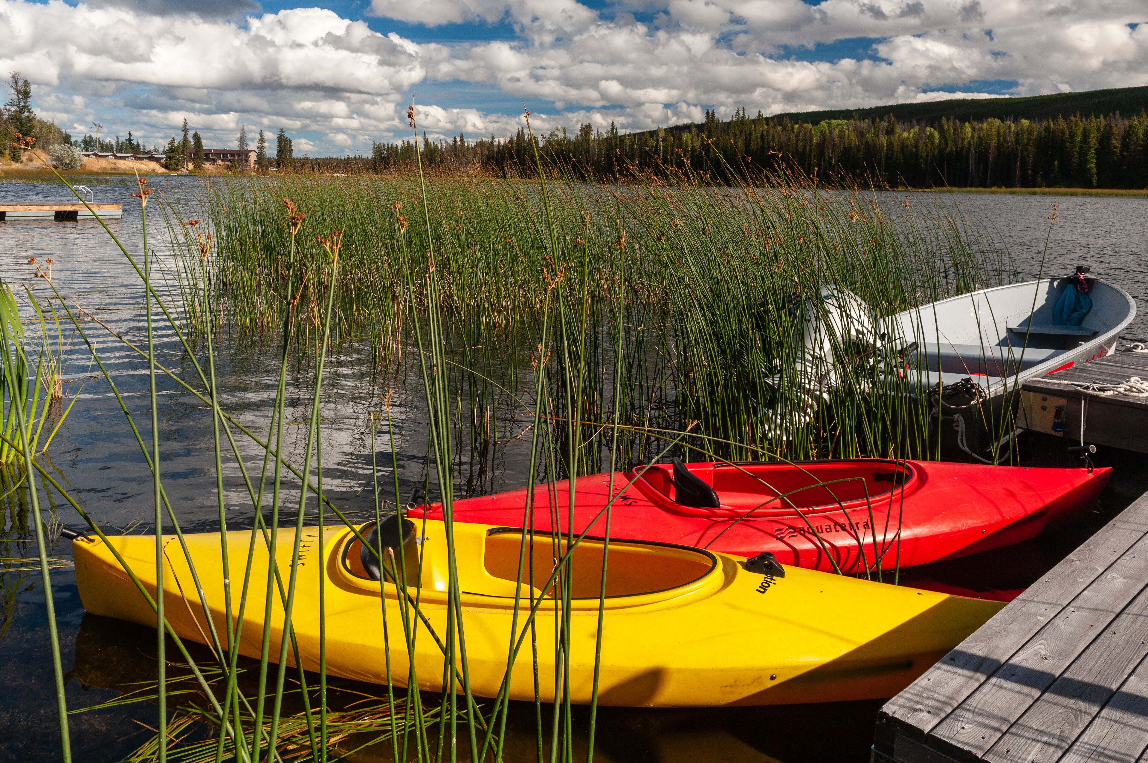 Ein ruhiger See mit Kajaks und einer Anlegestelle.
