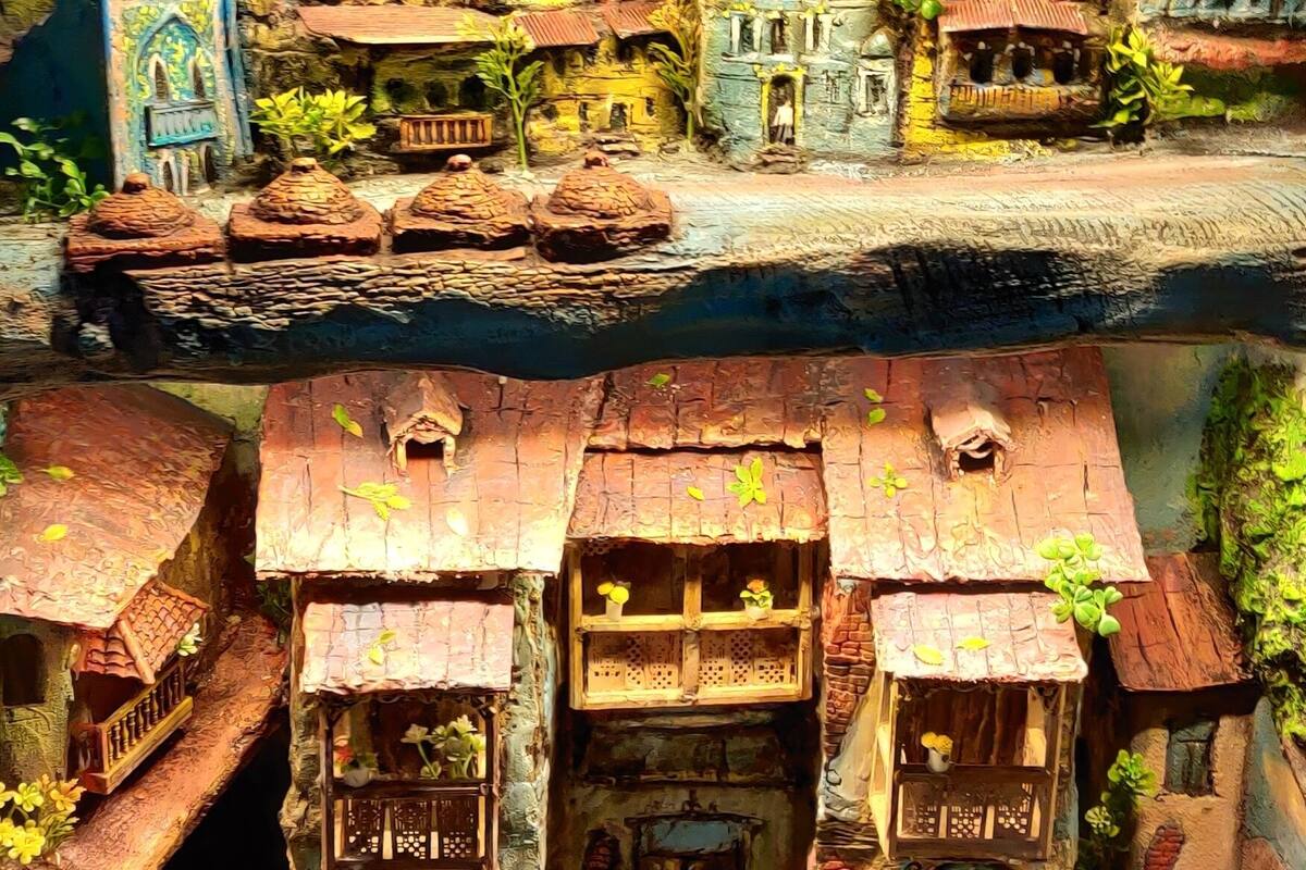 A detailed miniature model of a village with buildings, a church, and a river.