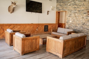 Ein Zimmer mit Holzmöbeln, einer Steinwand und einem aufgehängten Hirschkopf.
