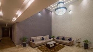 Uma sala de estar moderna com dois sofás, uma mesa de centro e plantas decorativas.
