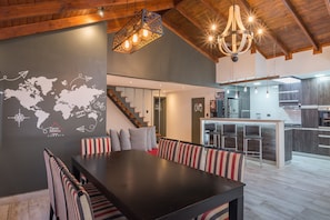 A modern interior with a dining area, kitchen, and staircase. - Cabañas Tierra Mistica (Ushuaia)