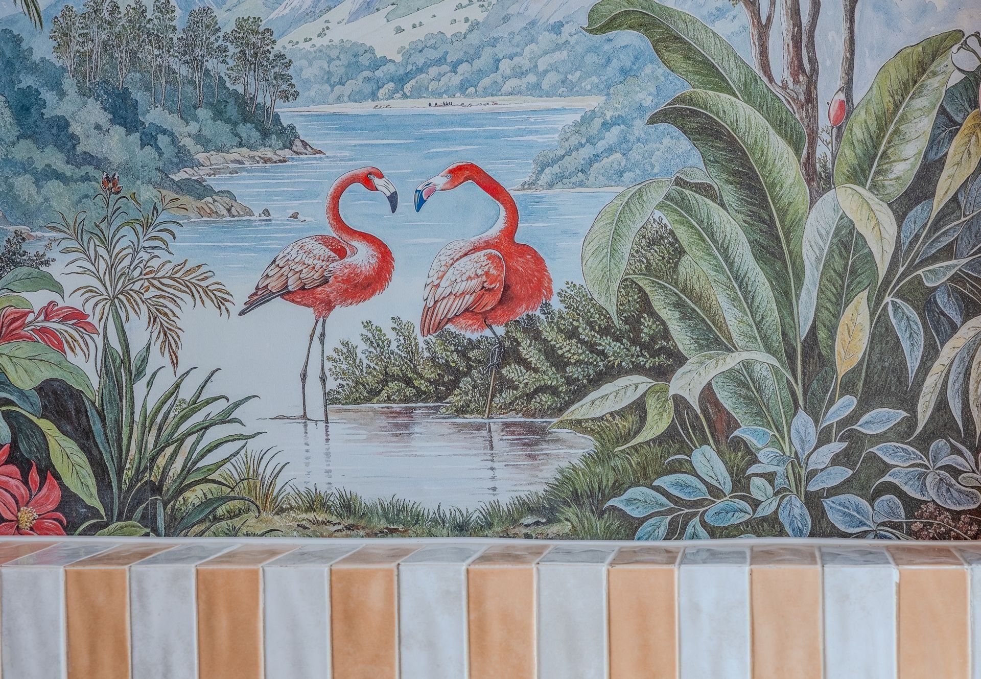Un mural con dos flamencos, una masa de agua y follaje circundante.