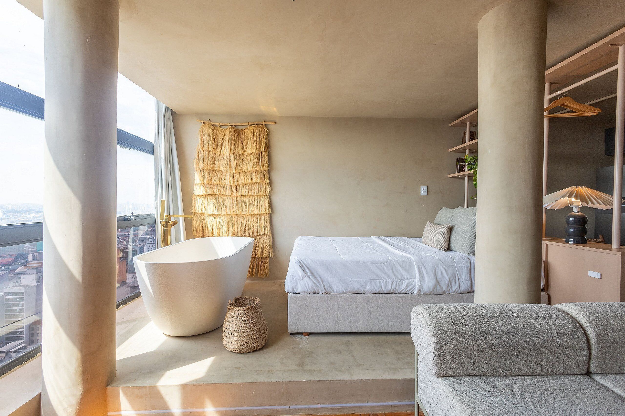 Quarto moderno com uma janela grande, banheira, sofá e cama.