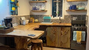 A kitchen with wooden furniture, a stove, and a coffee maker.