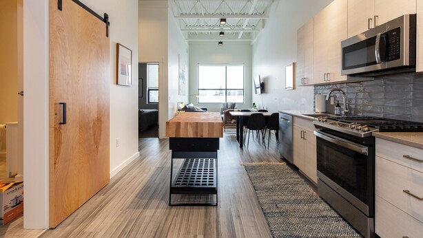 Una cocina moderna con un gran ventanal, comedor y una isla central.