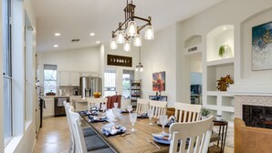 A spacious dining area with a wooden table set for a meal, white chairs, and a chandelier. - Upscale Golfer's Oasis w/ Pool & Spa in Cave Creek (Cave Creek)