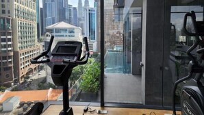 Un apartamento moderno con vistas a un horizonte urbano, que incluye un edificio destacado con dos torres gemelas.