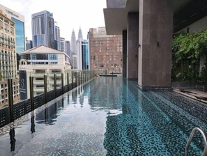 Ein Pool auf dem Dach mit Blick auf die Stadt, umgeben von Hochhäusern.