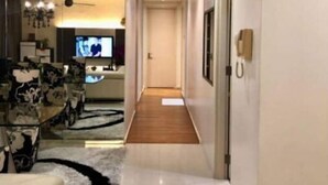 Moderni hotellihuone, jossa on suuri sänky, yöpöytä, yövalaisin ja ikkuna.