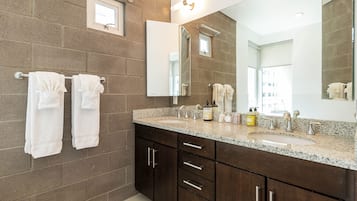 Un baño con dos lavamanos, muebles de madera oscura y un espejo grande.