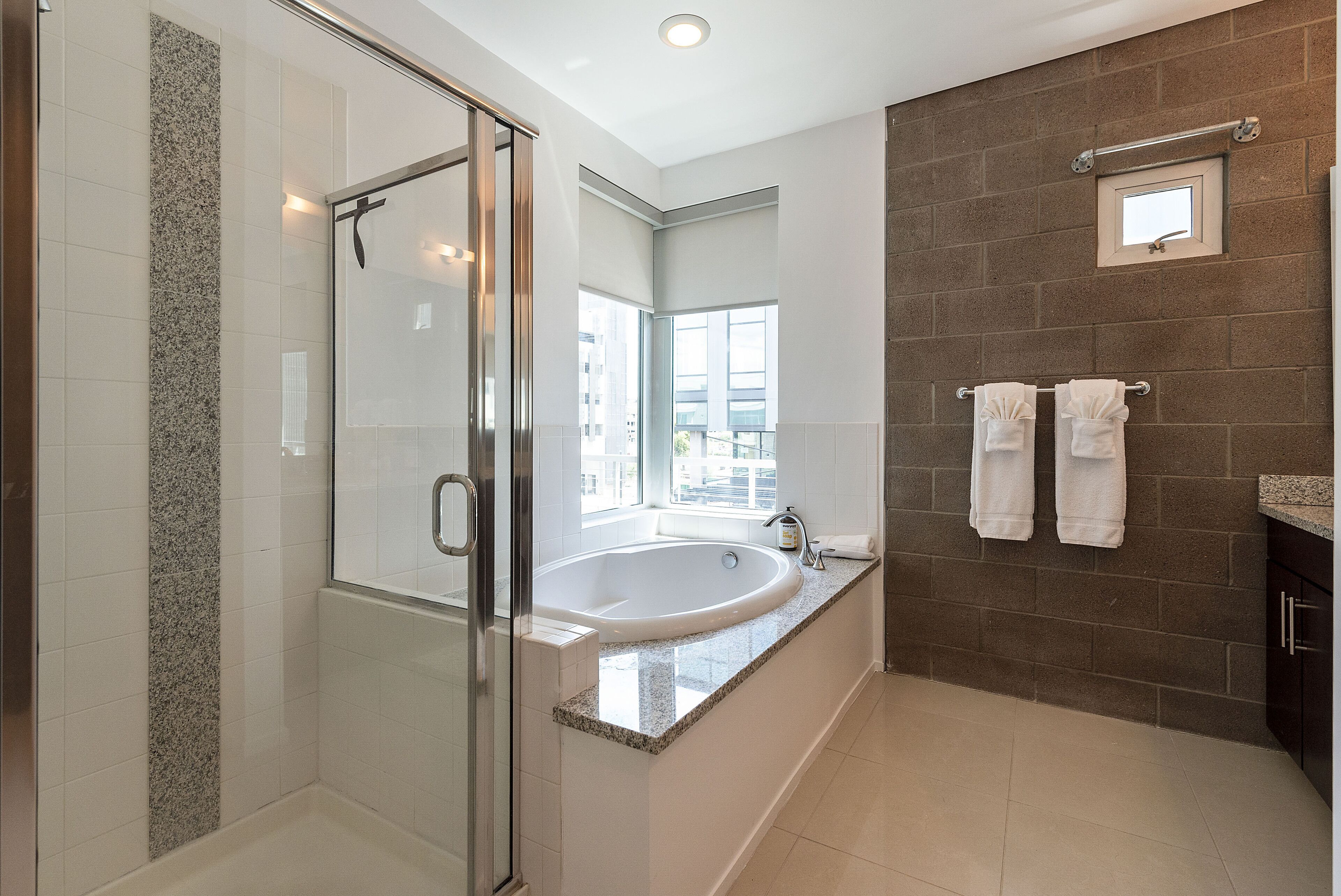 Une salle de bain moderne avec une douche à parois de verre, une baignoire sur pieds et un grand miroir.