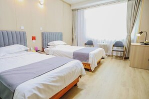A hotel room with two beds, a small table, a chair, and a desk with a lamp. - Bailong Hotel (Pingyin)