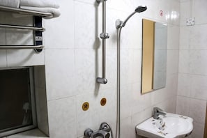 A bathroom with a shower, a sink, a towel rack, and a mirror.