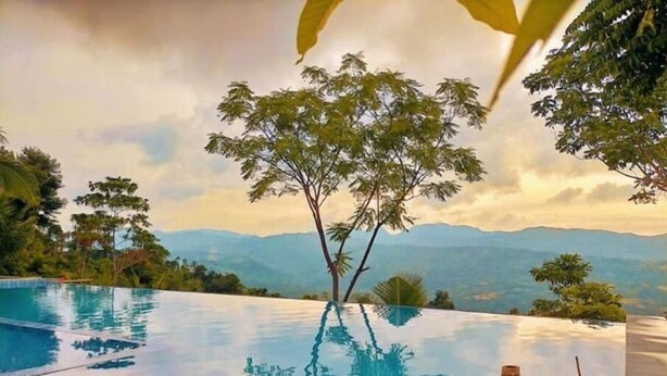 An infinity pool with a clear view of mountains and trees in the background. - Cozy B&B Mountain Getaway (Cebu City)