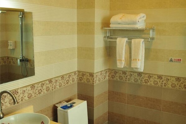 A bathroom with a sink, mirror, and a towel rack with towels. - Xiaolazhe Business Hotel (Jianchuan)