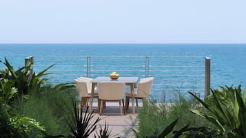 Una terraza con mesa y sillas que da al mar.