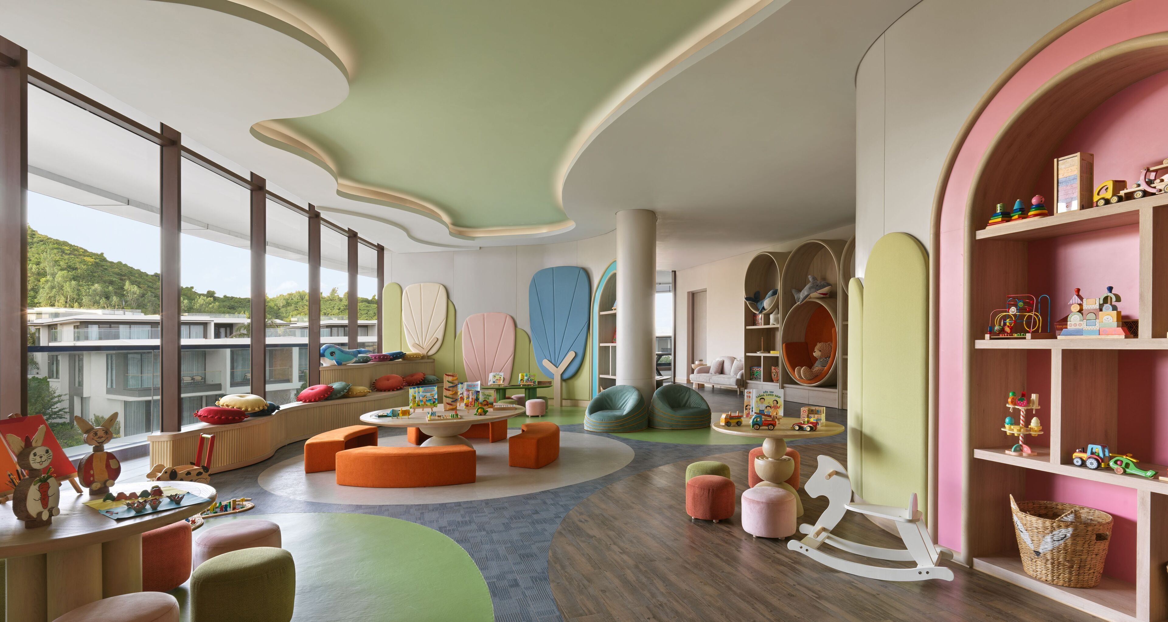 A children's playroom with colorful furniture, a large window, and a view of the outdoors.