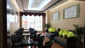 A lobby with a seating area, tables, and potted plants. - Duomi Chain Hotel (Lijiang Ancient City) (Lijiang)
