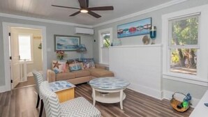 A room with a ceiling fan, a sofa, a small table, and a window with blinds. - ArtSea2. 2BR · Upstairs w/Ample Parking | Near Beaches & LECOM (Bradenton)