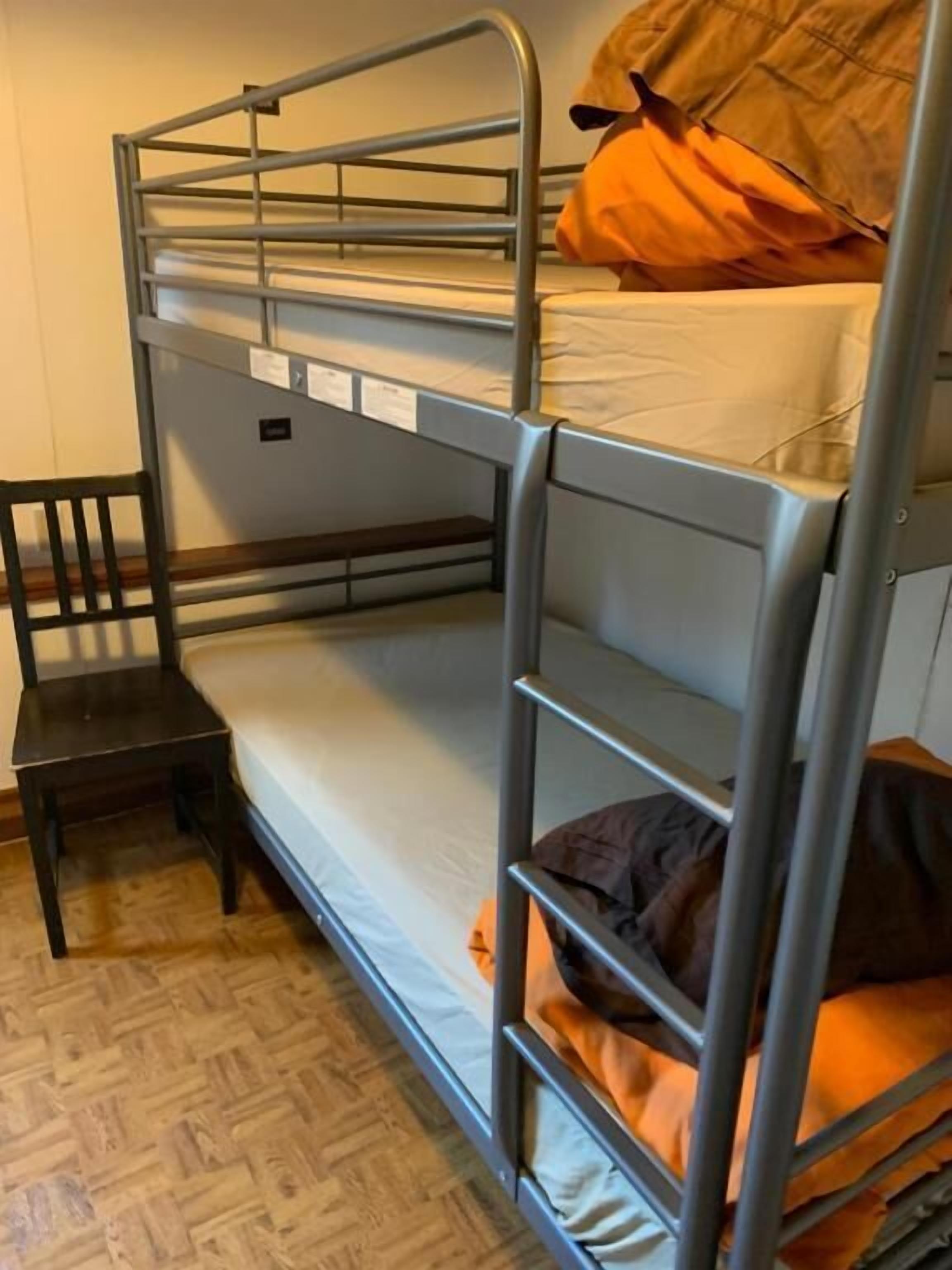 En køjeseng med træbænk og puder.