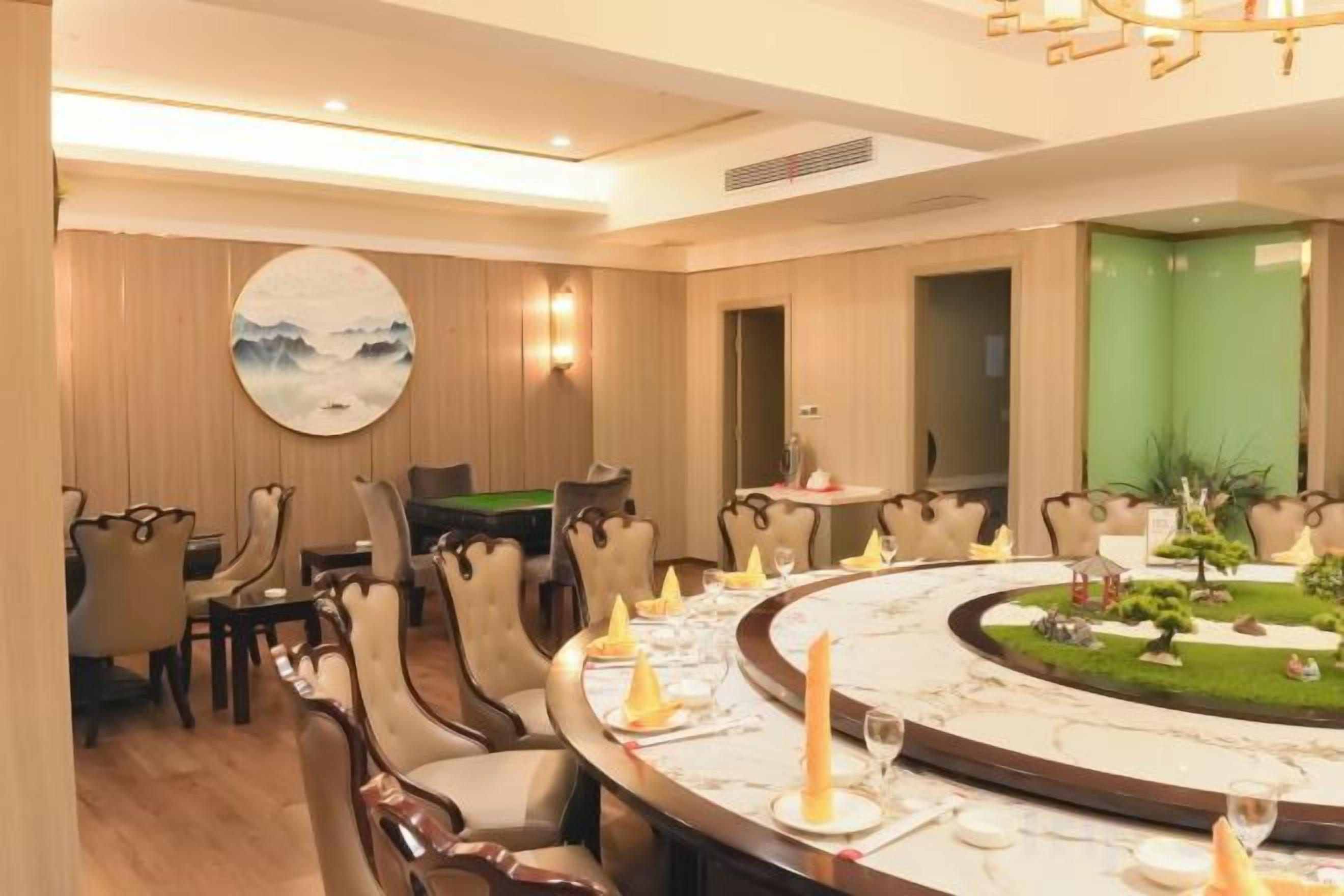 A dining area with a round table, chairs, and a small garden view.