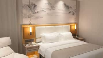 Una habitación de hotel con una cama grande, mesitas de noche y una obra de arte colgada en la pared.