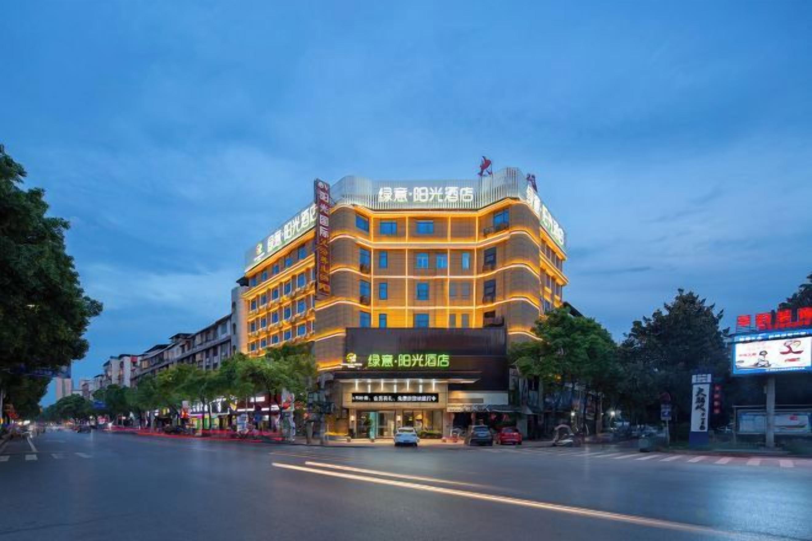 Un hotel de varios pisos con una entrada llamativa y señalización.