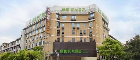 A multi-story hotel with a prominent sign for a restaurant on the ground floor.