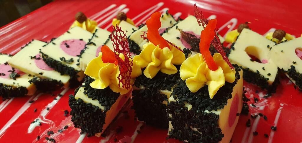 A dessert with a red background and white drips.