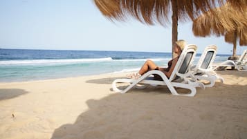 Een privéstrand, parasols, strandlakens, snorkelen