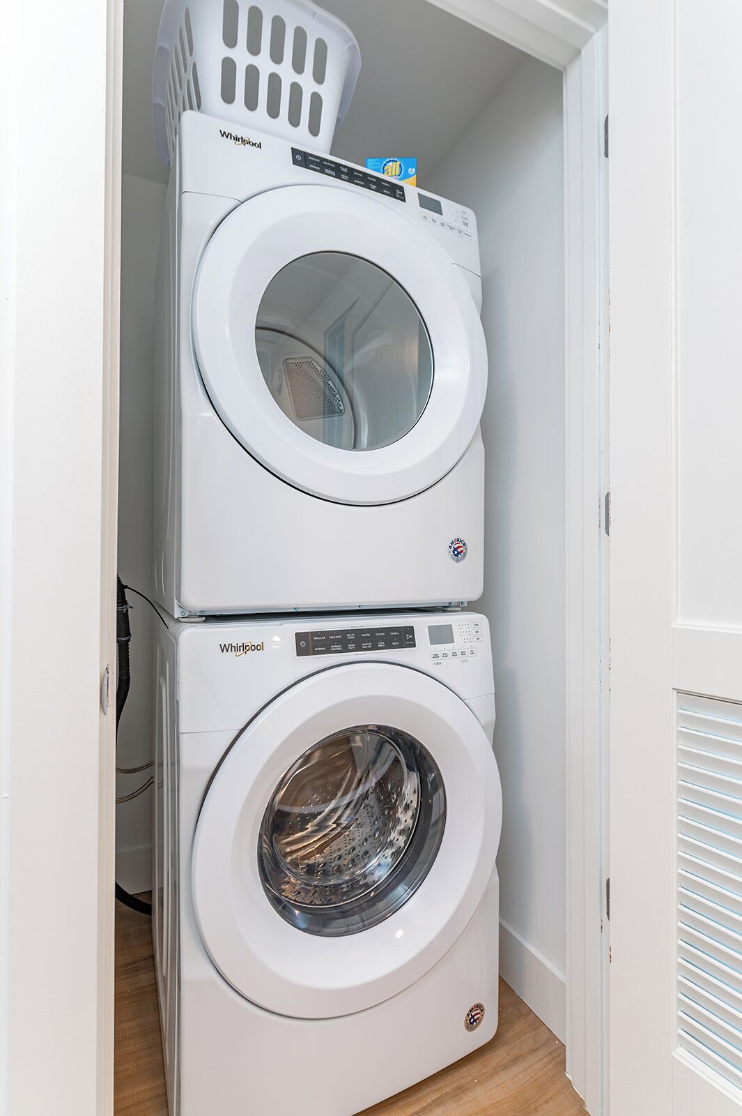 A stacked washer and dryer unit in a laundry room.