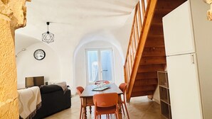 Un comedor con mesa, sillas y una escalera de madera.