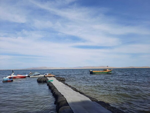 Un plan d’eau calme où des bateaux sont amarrés à un quai.