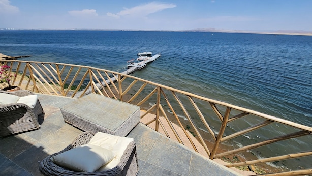 A terrace with wicker furniture and a view of the sea. - HOTEL BOUTIQUE ATENAS  (Paracas)