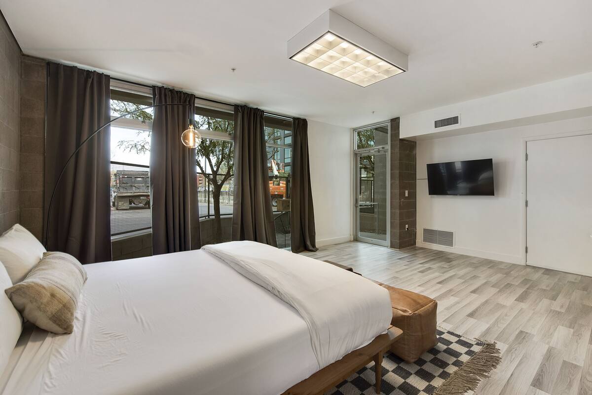 Un dormitorio moderno con una cama grande, televisión de pantalla plana y vistas al exterior.