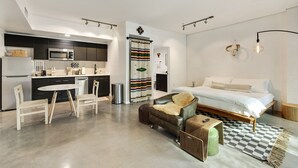 A modern apartment with a kitchen, dining area, and a bedroom. - Tempe Studios (Tempe)