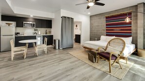 A modern apartment with a kitchen, dining area, and a bedroom. - Tempe Studios (Tempe)