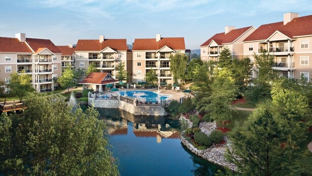 A multi-story residential building with a swimming pool and landscaped gardens. - 2BD Deluxe/Branson - w/Pools, Barbecue, Gym! (Branson)