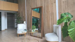 A modern interior with a wooden wall, a white sofa, a round table, and a large green plant. - LOFT LIMA -Depa- Magdalena del Mar (Lima)