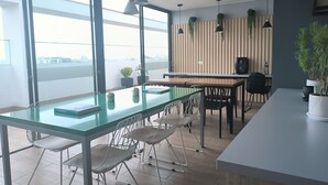A modern office space with a glass table, white chairs, and pendant lighting. - LOFT LIMA -Depa- Magdalena del Mar (Lima)