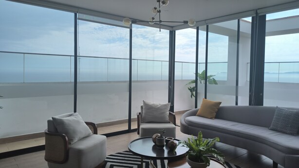 A modern living room with a large balcony, a sofa, armchairs, and a coffee table. - LOFT LIMA -Depa- Magdalena del Mar (Lima)