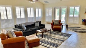 A spacious living room with a large sofa, two armchairs, a coffee table, and a fireplace. - Parkview Retreat- Lake View • Fire Pit • Hot Tub (Canyon Lake)