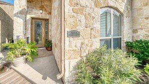 A stone building with a number plaque, a door, and potted plants. - Parkview Retreat- Lake View • Fire Pit • Hot Tub (Canyon Lake)