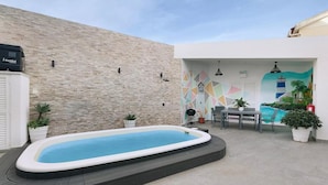 A swimming pool with a tiled deck, a stone wall, and a mural on the adjacent wall. - Impeccable 4-bed House in São Domingos de Rana (Cascais)