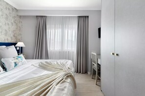 A hotel room with a bed, a desk, and a wardrobe. - Impeccable 4-bed House in São Domingos de Rana (Cascais)
