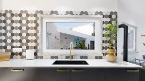A modern kitchen with a window, a sink, and a vase with a plant. - Impeccable 4-bed House in São Domingos de Rana (Cascais)